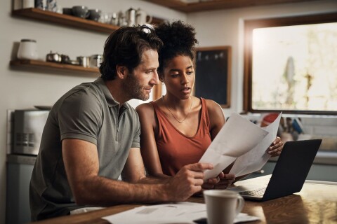 Stel neemt aan de keukentafel samen de financiele post en rekeningen door