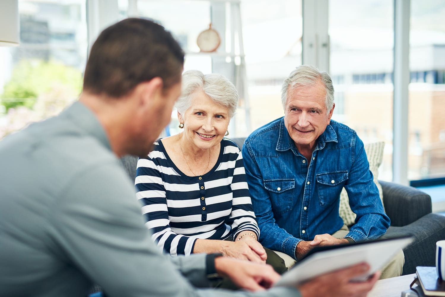 Ouder echtpaar in gesprek met een adviseur over hun financiele toekomst en zorg voor later
